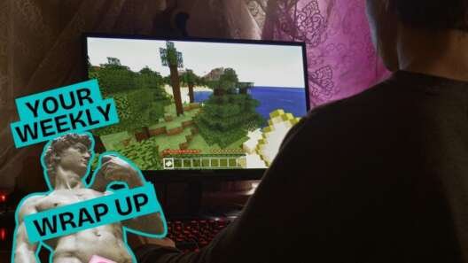 A person sits at a desk playing a video game on a computer monitor showing a block-style landscape. On the left, a graphic reads “Your Weekly Wrap Up” beside a stylised classical statue outlined in teal, partially covered by a pink censor-style sticker.
