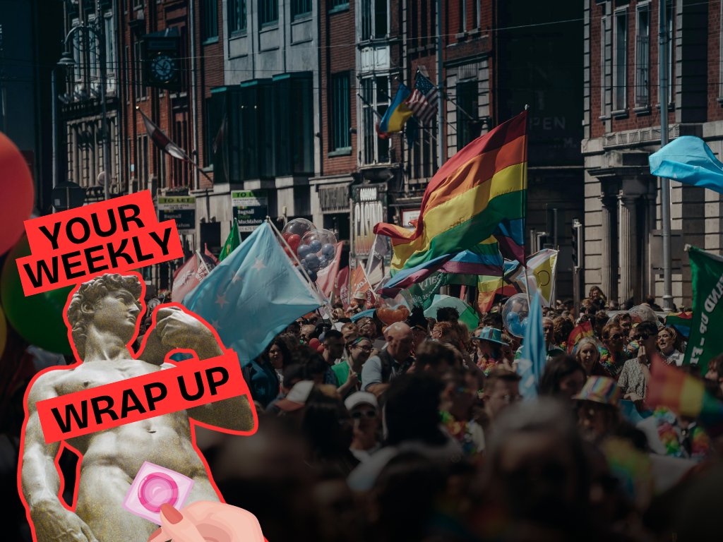 Crowds gather at a Pride march in a city street, with rainbow and transgender flags visible above the crowd. A “Your Weekly Wrap Up” graphic featuring a classical statue and a condom illustration appears in the bottom left corner.