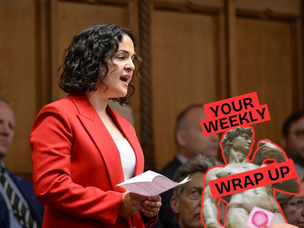 A person wearing a bright red blazer speaks while holding papers in a parliamentary chamber, with seated people visible in the background. A “Your Weekly Wrap Up” graphic featuring a classical statue and a condom illustration appears in the bottom right corner.